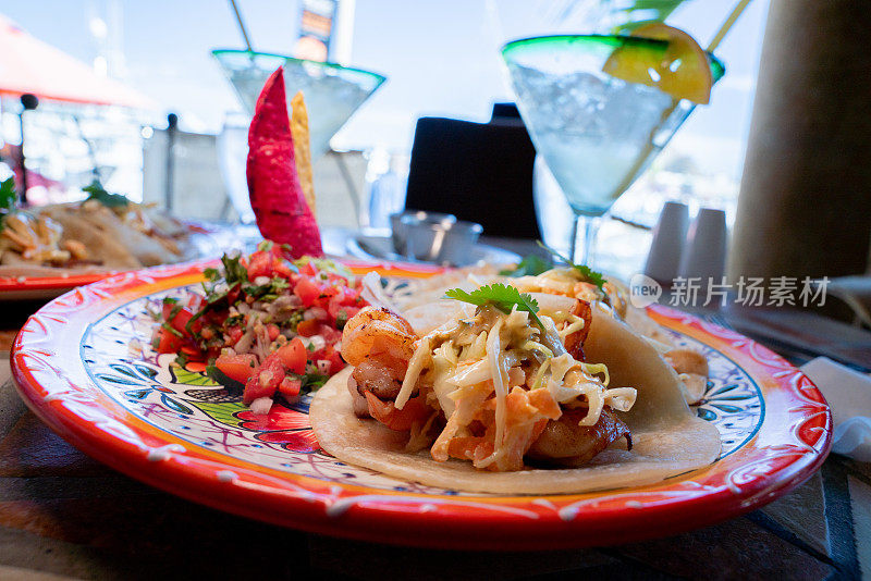 墨西哥卡波圣卢卡斯(Cabo San Lucas)的一家码头咖啡馆里，虾鱼街玉米饼配香菜、萨尔萨辣酱和一杯玛格丽塔(Margarita)